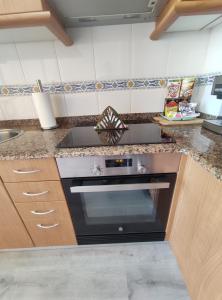 a kitchen with a stove and a counter top at Apartamento Tamarisco in Foz