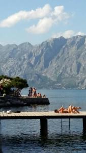 a group of people laying on a dock in the water at Holiday house in Kotor