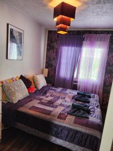 una camera da letto con un grande letto con tende viola di Stuga Ani a Svartå