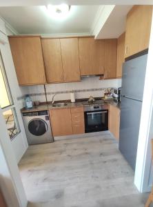 una piccola cucina con armadi in legno e lavastoviglie di Apartamento Tamarisco a Foz