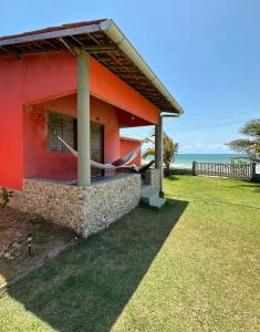 a red house with the ocean in the background at Takito Kite House, Praia da Baleia, Itapipoca CE in Franco