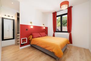 a bedroom with a large bed with a red headboard at Maison de charme Bordeaux Bègles in Bègles