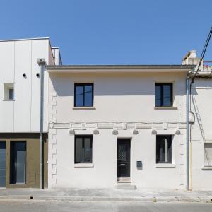 a white building with black windows at Maison de charme Bordeaux Bègles in Bègles