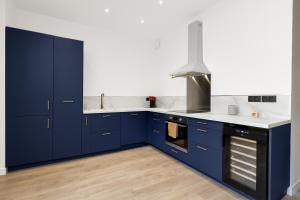 a kitchen with blue cabinets and white counter tops at Maison de charme Bordeaux Bègles in Bègles