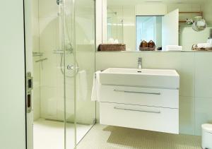 bagno bianco con lavandino e doccia di Stay at Night - Moonlight a Zurigo