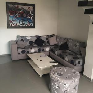 a living room with a couch and a coffee table at TRIPLEX L'OCÉAN in Safi
