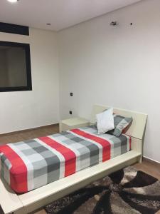 sypialnia z łóżkiem z czerwonym białym i czarnym paskiem w obiekcie TRIPLEX L'OCÉAN w mieście Safi