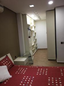 una habitación con una cama roja y una habitación con estanterías en TRIPLEX L'OCÉAN en Safi