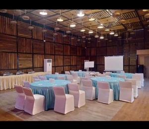 Habitación grande con mesas azules y sillas blancas. en PRIME LAND, en Varanasi