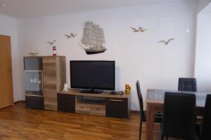 a living room with a tv and a ship on the wall at Stralsunder in Stralsund