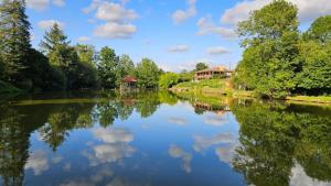 un río con un reflejo de una casa en el agua en Lake Noble, en Saint-Germain-lʼAiguiller