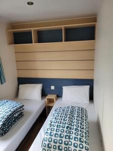 duas camas num pequeno quarto com azul e branco em le Petit futé 112 em Biville-sur-Mer