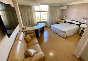 Habitación de hotel con cama y sofá en Hotel Maerkli en Santo Ângelo