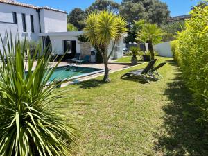 a garden with a swimming pool and a house at Le Minamo Studio in Six-Fours-les-Plages
