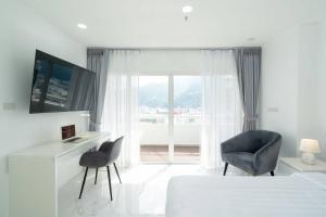 een slaapkamer met een bed, een bureau en een stoel bij Patong Tower Brand New 1-Bedroom , Near Beach in Patong Beach