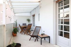 un patio al aire libre con sillas y mesa en The Terrace Kiss, en Atenas