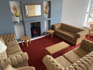 a living room with two couches and a fireplace at Monarch Hotel in Bridlington