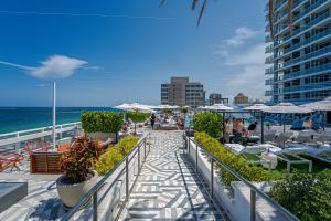 フォート・ローダーデールにあるBeachfront-Spacious W Residenceのビーチに椅子とパラソルが置かれた歩道
