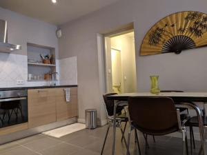 een keuken met een tafel en stoelen in een kamer bij Bel appartement dans centre historique avignon in Avignon
