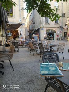 een groep tafels en stoelen in een stadsstraat bij Bel appartement dans centre historique avignon in Avignon