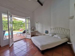 a bedroom with a bed and a sliding glass door at Villa sur la dune, superbe vue, jacuzzi, piscine chauffée in La Teste-de-Buch