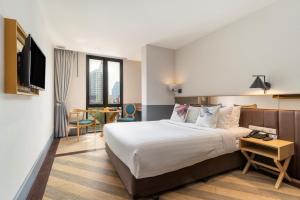 um quarto de hotel com uma cama e uma televisão em Vince Hotel Pratunam em Banguecoque