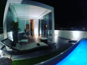 a villa with a swimming pool at night at 18 Dante Luxury Suites in Cagliari