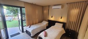 um quarto de hotel com duas camas e uma varanda em הבית של דבורה ומשה em El'ad