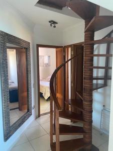 eine Holztreppe in einem Zimmer mit Spiegel in der Unterkunft Cobertura de frente para o Mar in Caraguatatuba