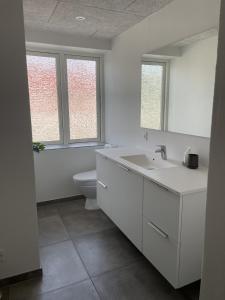 3 værelses lejlighed i Give في جايف: حمام أبيض مع حوض ومرحاض