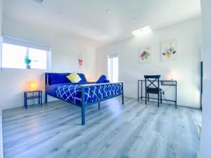 a bedroom with a blue bed and two chairs at Stylish 3 BR/3BR family house in Los Angeles