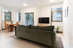 un salon avec un canapé et une télévision dans l'établissement Eliezer Ben Yehuda Residence WITH SHELTER, à Tel Aviv