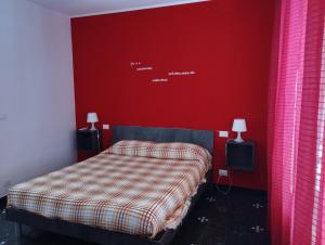 - une chambre avec un lit et un mur rouge dans l'établissement DOMUS SUPERBA, à Gênes