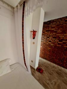 um quarto com uma cama e uma parede de tijolos em GKAT Resort em Mbarara