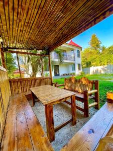 Villa in Chakvi في شاكفي: طاولة وكراسي للتنزه خشبية تحت بروغولا خشبي