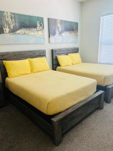 two beds in a room with yellow pillows at One bedroom apt near NRG and Medical Ctr in Houston