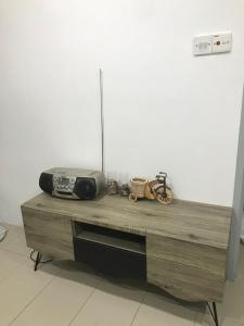 una mesa de madera con radio y otros artículos. en M1 Budget Comfortable Central en Kuching
