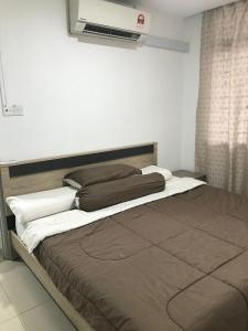 a bed in a bedroom with a air conditioner on the wall at M1 Budget Comfortable Central in Kuching