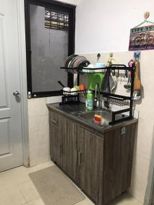 a kitchen with a sink and a dish drying rack at M1 Budget Comfortable Central in Kuching