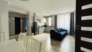 a living room with a blue couch and a kitchen at Sopot Marina Beach Elegance in Sopot +83 photos