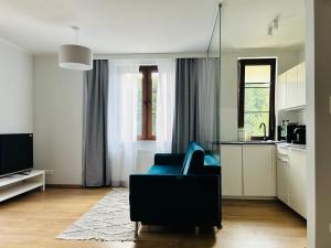 Sopot Marina Beach Suites في سوبوت: غرفة معيشة مع كرسي ازرق ومطبخ