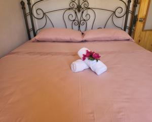 ein Bett mit zwei Handtüchern und Blumen drauf in der Unterkunft MILA Apartments #1 in Barco Quebrado