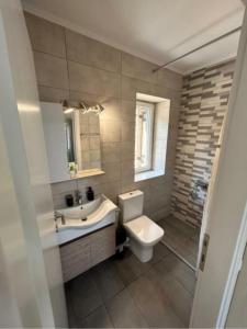 a bathroom with a sink and a toilet and a mirror at Anmare Studios in Nydri