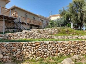a stone retaining wall in front of a building at Anmare Studios in Nydri +8 photos
