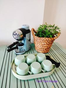 ein Tablett mit Kaffeetassen und einer Kaffeemaschine auf dem Tisch in der Unterkunft Khu nghĩ dưỡng Emeral Golf View in Thuan An
