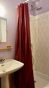 uma casa de banho com uma cortina de chuveiro vermelha ao lado de um lavatório em Duplex Paris & Parc des Princes em Boulogne-Billancourt