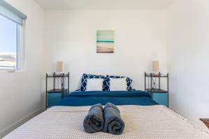 a bedroom with a blue bed with two pairs of socks on it at Cheerful 4BR home with parking in East Hollywood in Los Angeles