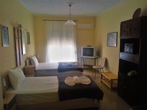 a hotel room with two beds and a television at Alkioni City Apartments in Chania Town