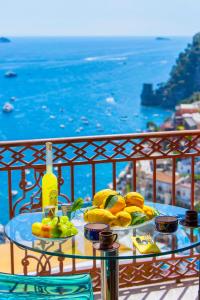 a glass table with food on top of a balcony at AMORE RENTALS - Casa Volte Alte in Positano