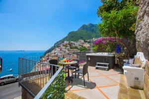 a balcony with a table and chairs overlooking the ocean at AMORE RENTALS - Casa Volte Alte in Positano